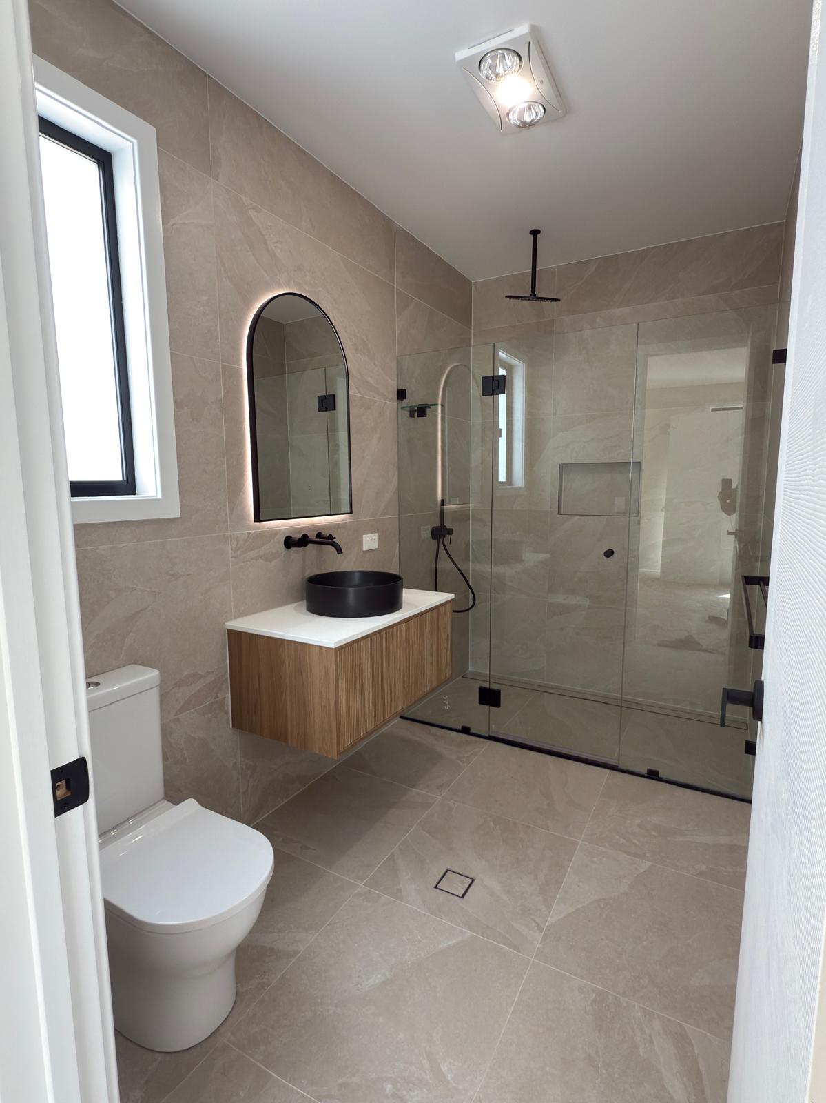 Ensuite — arched mirror & rain shower — plumbing work completed in Oak Flats by Shellharbour Plumbing (licensed Illawarra plumber)