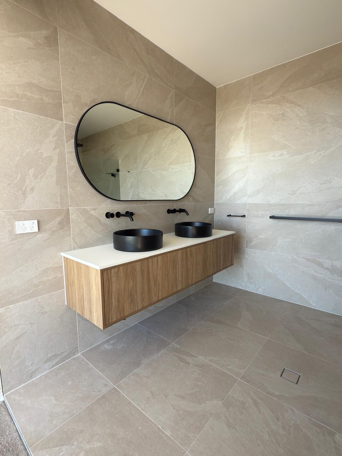 Master ensuite — pebble mirror & matte black — plumbing work completed in Shell Cove by Shellharbour Plumbing (licensed Illawarra plumber)