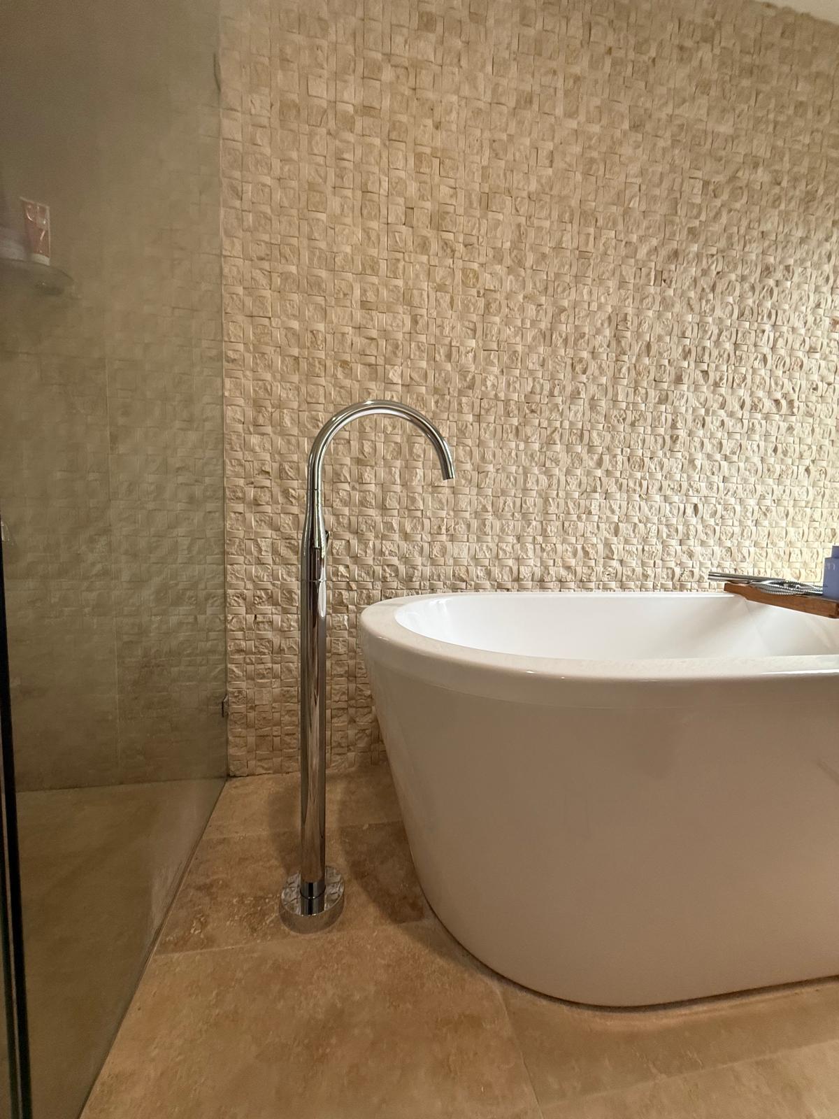 Freestanding bath — stone mosaic feature wall — plumbing work completed in Gerringong by Shellharbour Plumbing (licensed Illawarra plumber)