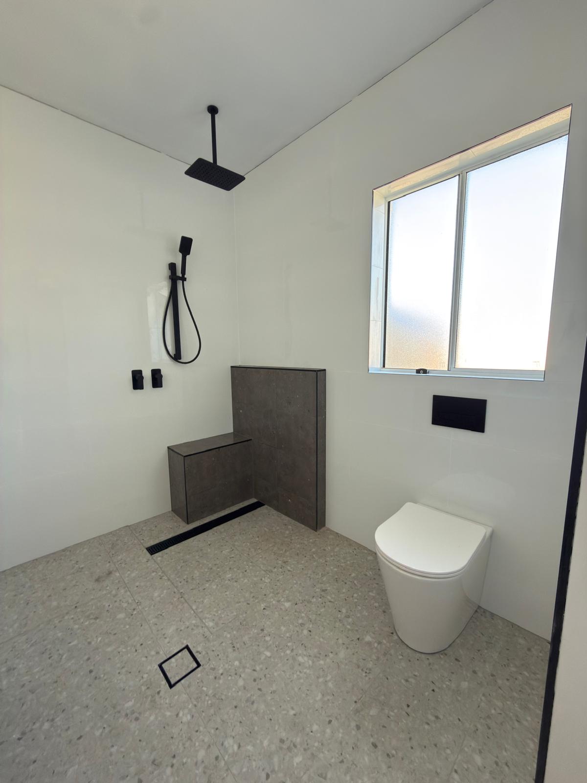Wet room — terrazzo floor & matte black tapware — plumbing work completed in Shell Cove by Shellharbour Plumbing (licensed Illawarra plumber)